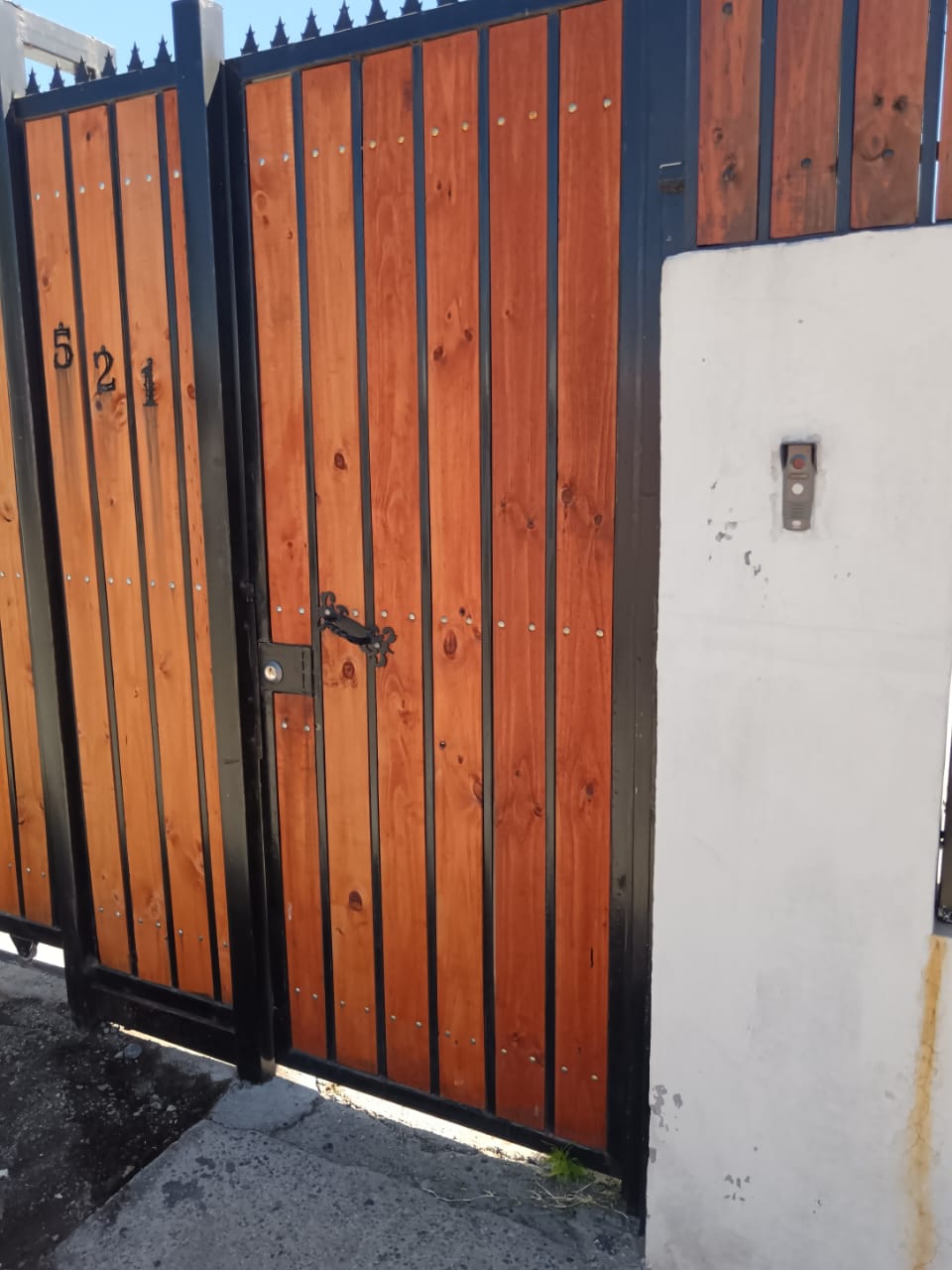 Portón de madera y metal para acceso vehicular